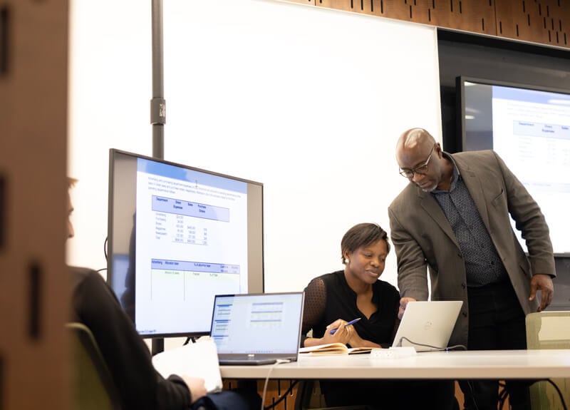 A professor instructs a graduate student during an accounting course.